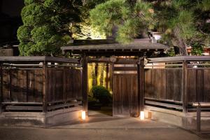an entrance to a garden with a wooden gate with lights at 丹徳庭園 in Kawagoe
