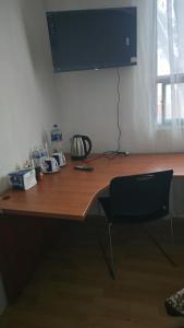 a wooden desk with a chair and a monitor on it at Recamara tipo cabaña in Mexico City