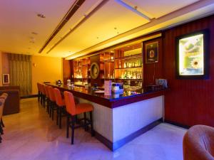 un bar in un ristorante con sedie arancioni di Grand Elite Hotel Pekanbaru a Pekanbaru