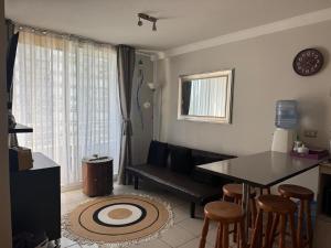 a living room with a couch and a table and chairs at Acogedor apartamento in Quilpué