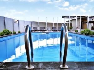 una piscina en un hotel con agua azul en Grand Elite Hotel Pekanbaru en Pekanbaru