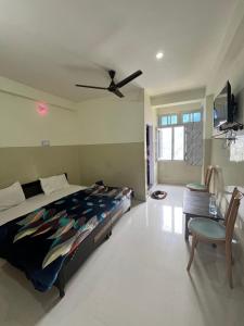 a bedroom with a bed and a ceiling fan at Hotel Manimahesh Bharmour in Brāhmaur