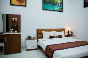 a bedroom with a bed and a desk in a room at Nhat Quang Hotel in Bảo Lộc