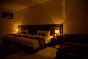 a hotel room with two beds and a couch at Nhat Quang Hotel in Bảo Lộc +23 photos