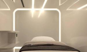 a bed in a room with a light on it at The Rich Cafe & Hostel in Pattaya South