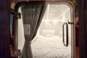 a small room with a bed and a curtain at The Rich Cafe & Hostel in Pattaya South