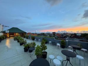 a rooftop patio with tables and chairs at sunset at Suardana Inn's in Kuta