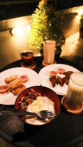a table with a bowl of food and plates of food at Suardana Inn's in Kuta