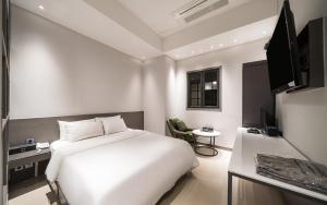 a bedroom with a large white bed and a desk at HOTEL MYEONG JAK in Suwon +100 photos