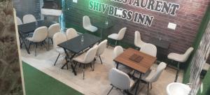 a group of tables and chairs in front of a brick wall at hotel shiv bliss inn Dibai in Dibai