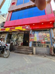 a man riding a motorcycle in front of a restaurant at hotel shiv bliss inn Dibai in Dibai