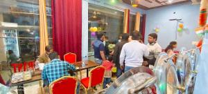 a group of people standing around in a restaurant at hotel shiv bliss inn Dibai in Dibai +7 photos