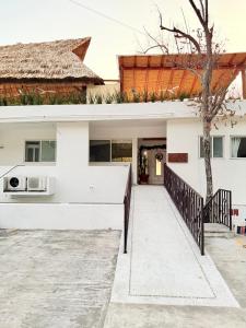 a white house with a porch and a tree at Villa Linda in Acapulco +4 photos