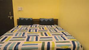 a bedroom with a large bed with a colorful comforter at hotel shiv bliss inn Dibai in Dibai