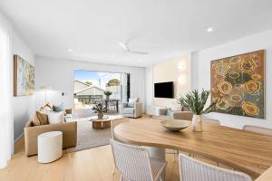 a living room with a table and a dining room at Key West Beach House in Coolum Beach +28 photos