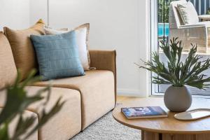 a living room with a couch and a table with a plant at Key West Beach House in Coolum Beach