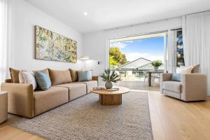 a living room with a couch and a table at Key West Beach House in Coolum Beach