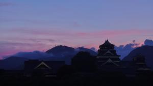 a silhouette of buildings and mountains at sunset at Kumamoto Hotel Castle in Kumamoto