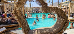 a group of people in a swimming pool at Hotel Pleasure Blackbeach Santorini in Perissa