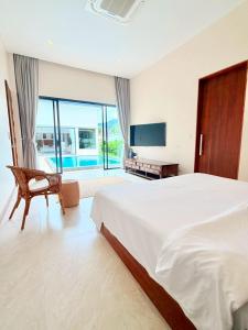 a bedroom with a bed and a chair and a television at Bella Villa V1 in Koh Lone