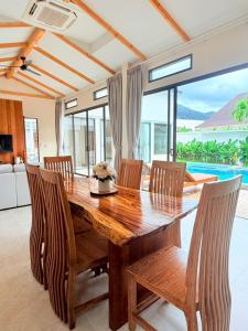 a dining room with a wooden table and chairs at Bella Villa V1 in Koh Lone
