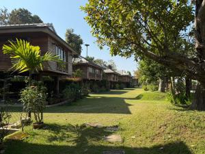 a row of cottages in a resort yard at เพลินนะเพลินนา รีสอร์ต Ploennaploenna in Ban Rim Lao +8 photos