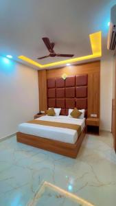 a bedroom with a large bed with a wooden headboard at Hotel Shree Amrit Ganga in Haridwār