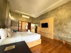 a hotel room with a bed and a television at เพลินนะเพลินนา รีสอร์ต Ploennaploenna in Ban Rim Lao