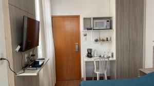 a small hotel room with a bed and a small table at Lagoa Flats in Lagoa Santa