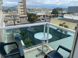 a balcony with a table and chairs and a view at Lagoa Flats in Lagoa Santa