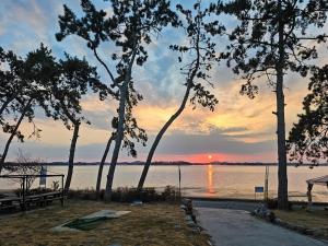a sunset over a body of water with trees at Muan Topmeori Pension in Muan