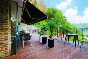 a deck with a table and chairs and an umbrella at Pygmalion Effect in Chuncheon