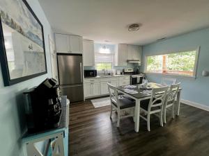 a kitchen with a table and chairs and a refrigerator at Dockside Dreamz 2 with beach & dock in Clarksville