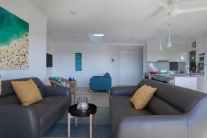 a living room with two couches and a table at Villa Pandanus in Peregian Beach