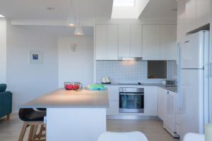 a kitchen with white cabinets and a counter top at Villa Pandanus in Peregian Beach