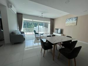 a living room with a dining room table and chairs at Homestays Batu Ferringhi in Batu Ferringhi