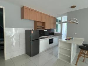 a kitchen with a refrigerator and a table in it at Homestays Batu Ferringhi in Batu Ferringhi