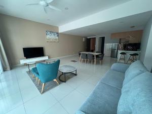 a living room with a blue couch and a television at Homestays Batu Ferringhi in Batu Ferringhi +11 photos