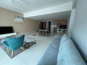 a living room with a blue couch and a kitchen at Homestays Batu Ferringhi in Batu Ferringhi