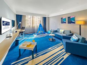a living room with a blue couch and a tv at Holiday Inn Express Zhangye by IHG in Zhangye