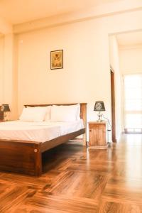 a bedroom with a bed and a wooden floor at Unawa Retreat in Tissamaharama