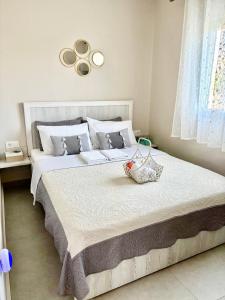 a bedroom with a large white bed with a basket on it at Dream Summer House in Nea Kallikrateia