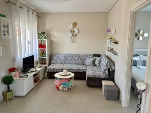 a living room with a couch and a tv at Dream Summer House in Nea Kallikrateia