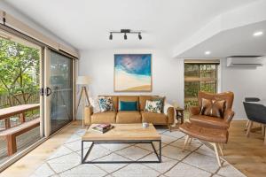 a living room with a couch and a table at Peregian Beach Apartment in Peregian Beach