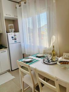 a kitchen with a table with chairs and a refrigerator at Dream Summer House in Nea Kallikrateia