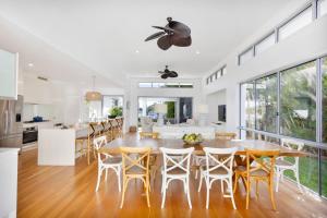 a kitchen and dining room with a table and chairs at Hampton Beach House on the Waterfront in Buddina