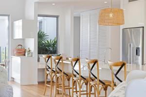 a kitchen with a dining room table and chairs at Hampton Beach House on the Waterfront in Buddina
