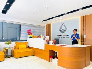 a woman standing at a reception desk in a office at Walk Street Hotel & Apartment in Phnom Penh