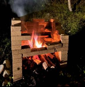 a brick fireplace with a fire in it at 愛犬と泊まるグランピングJuden Camp Fuji in Yamanakako