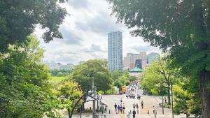 a group of people walking down a street in a city at Ueno Sakura Inn 上野公园 in Tokyo